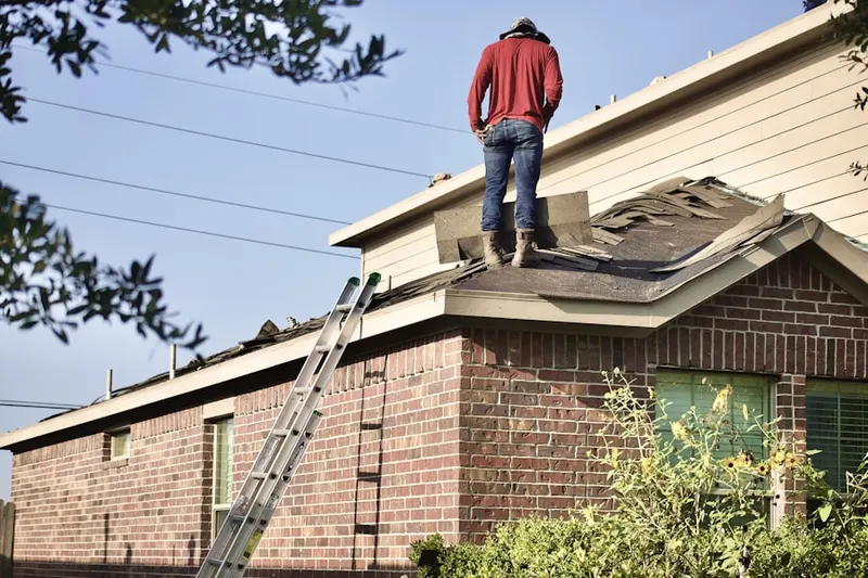 Professional roofer working on a residential roof in Claghorn